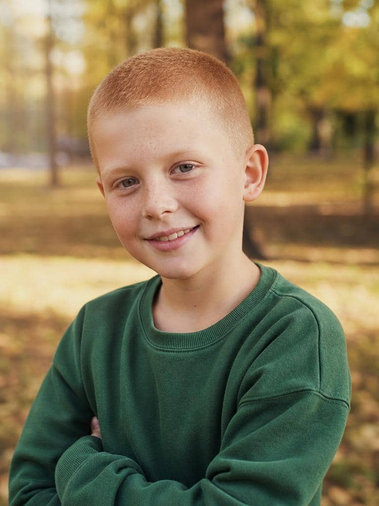 Buzz cut dla chłopca w rudym odcieniu w parku